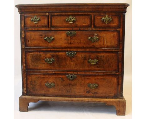 A George I walnut chest of drawers
The crossbanded rectangular top with herringbone inlay and canted front corners, above thr