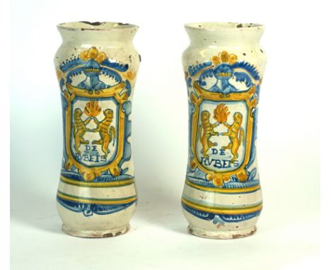 A pair of Delft vases of cylindrical wasted form
Painted in enamel of blue and amber depicting a knight holding a shield with