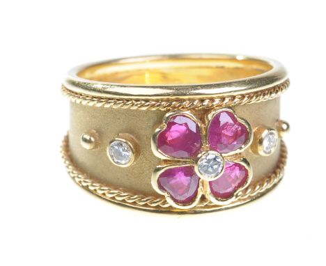 A contemporary 18ct gold ruby and diamond set dress ring
Centrally set with four heart cut rubies in a four leaf clover desig