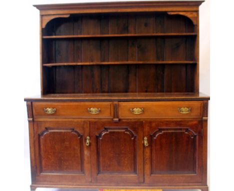An 18th Century-style oak high dresser, of later construction
The moulded cornice above two open-fronted shelves, the base se