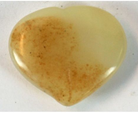 A Chinese pale celadon jade belt buckle carved in the form of a peach 
With russet inclusions, height 6cm
