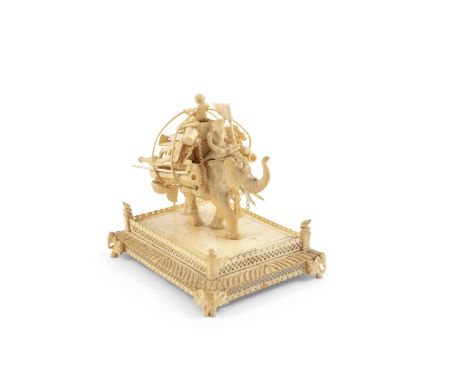 A SMALL INDIAN CARVED IVORY GROUP, 19th Century, formed as a travelling tradesman sitting on top of a striding elephant and c