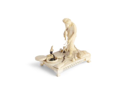 AN INDIAN CARVED IVORY FIGURAL GROUP, 19th Century,  modelled as a snake charmer standing playing a pungi with a cobra and ot