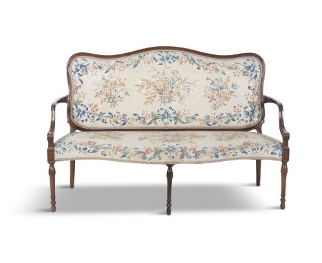 AN EDWARDIAN MAHOGANY FRAMED SERPENTINE FRONT SETTEE, the arch top panel back and seat covered in foliate pattern tapestry cl