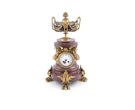 A FRENCH ROUGE MARBLE AND GILT METAL MOUNTED MANTLE CLOCK, 19TH CENTURY, surmounted with an urn and flambeau finial, supporte