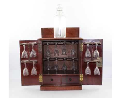 A 19TH CENTURY MAHOGANY LIQUOR CABINET, fitted brass side carrying handles, the front doors open to reveal cut stemmed glasse