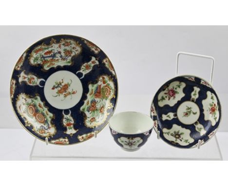 THREE PIECES OF WORCESTER BLUE SCALE GROUND PORCELAIN; a tea bowl with saucer painted with floral reserves and a plate gilded