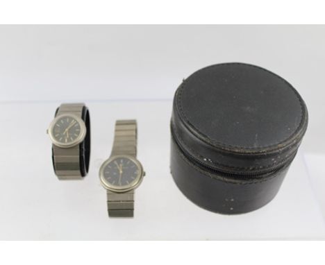 A PAIR OF "PORSCHE" DESIGN TITANIUM WRIST WATCHES, one lady's, one gentleman's, each having black dial with gold coloured bat