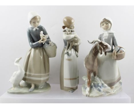 THREE LLADRO PORCELAIN FIGURINES, includes a girl with a basket and goat, 22cm high, a girl carrying a goat, and a goose girl