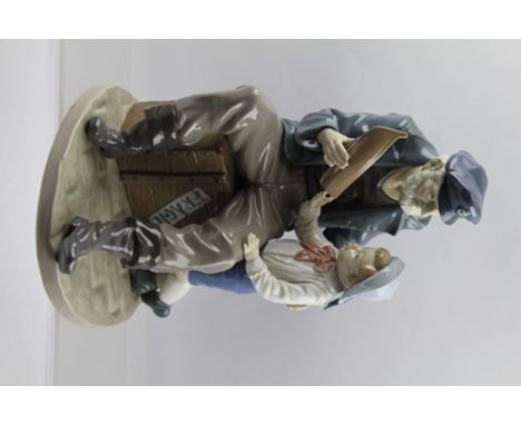 A LLADRO PORCELAIN FIGURE OF AN OLD SAILOR seated upon a crate, showing a model boat to a boy, 29cm high 