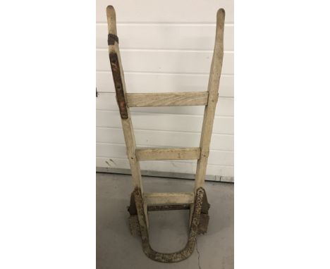 A vintage wooden sack barrow with cast iron wheels.   Total height approx. 91cm.