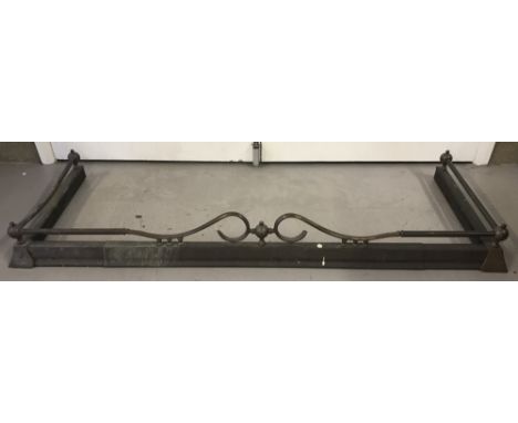 A vintage brass fire surround with galleried sides and scroll design to front.   Approx. 142cm long.
