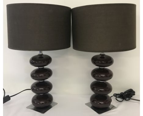 A matching pair of 1970's brown ceramic table lamps. On square, chromed metal bases, with shades. Approx. H50cm.