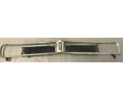 A vintage Vauxhall Viva front grill. Aluminium trim with black plastic interior grill.   Approx. 146cm long.
