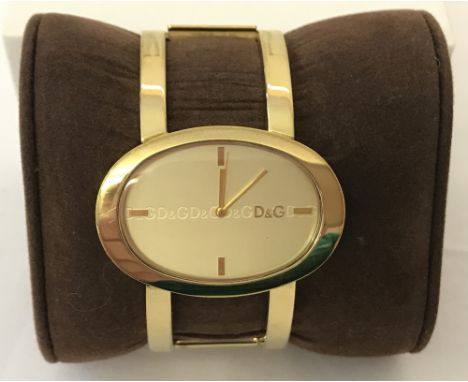 A ladies gold tone Dolce and Gabbana bangle wrist watch.  D &amp; G logo to face and back of case. Working order. 