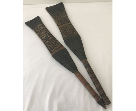 2 vintage shaped tribal paddles with turned finials to handles and hand painted details to paddle.   Largest approx. 63cm lon