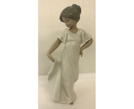 A Nao ceramic figurine of a girl holding her dress "How Pretty".   Approx. 21.5cm tall.