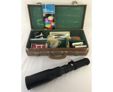 A vintage suitcase containing a Paragon 500mm telephoto lens. Together with an assortment of camera accessories. 