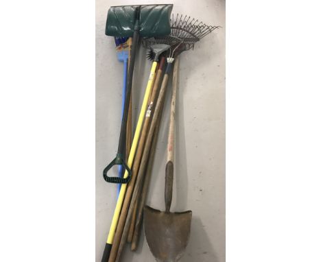 A collection of long handled tools.  To include a snow shovel, planting spade, rakes and a broom. 