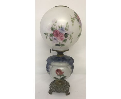 A vintage hand painted oil lamp with glass bowl and milk glass shade signed by Ticky Baniak. Metal 3 footed base with glass b