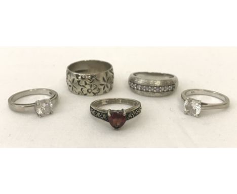 5 ladies silver dress rings to include stone set.  Comprising: a wedding band with floral decoration, one set with heart shap