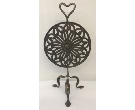 A Victorian metal fire screen. A circular pierced work revolving disc raised on tripod feet.   Approx. 63cm tall.