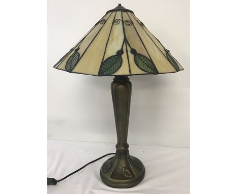 A Tiffany style table lamp with iridescent glass panels decorated with leaves.  Lamp base also decorated with leaves. Fixing 