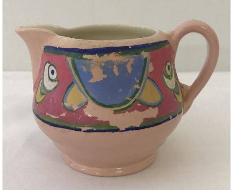 A Royal Staffordshire ceramics Clarice Cliff milk jug in pink with painted design detail.   Approx. 8cm tall.