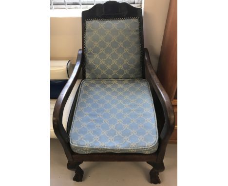 A dark oak framed vintage armchair with ball and claw feet and carved detail to top.  Pale blue and gold upholstery with stud