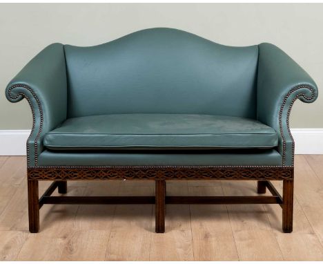 An antique camel back two seater settee with scrolling arms and blind fret carved decoration, 150cm wide x 64cm deep x 50cm h