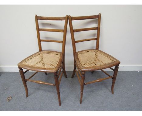 A pair of Victorian cane seated ladder-back chairs on stretchers