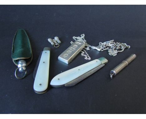 A silver ingot on chain, silver propelling toothpick, silver bladed mother of pearl handled fruit knives etc