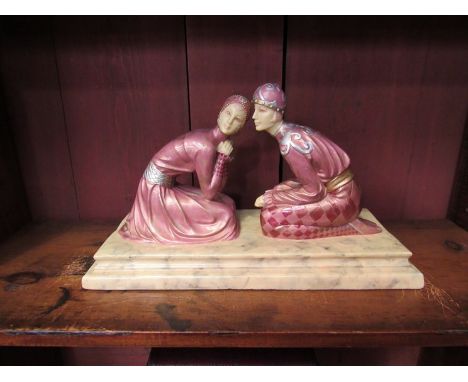 An Art Deco style figurine of couple kneeling on a marble plinth,  31cm long