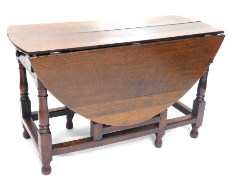 A late 17thC oak drop leaf gate leg table, on baluster supports joined by a heavy block stretcher, on orb feet, some parts la