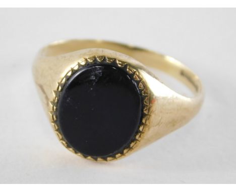 A 9ct gold gent's signet ring, with oval black agate panel, on a plain design band, ring size Q, 2.6g all in.