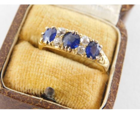 A sapphire and diamond half hoop dress ring, set with three oval cut sapphire each in claw setting, with four round brilliant