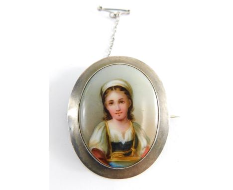 A late 19th/early 20thC portrait brooch, the oval hand painted portrait of young female in gown, in a white metal moulded fra