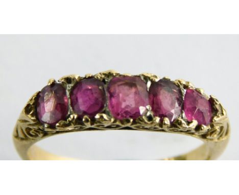 An 18ct gold ruby dress ring, set with five oval cut rubies, each in a scroll claw setting, yellow metal band stamped 18ct, r