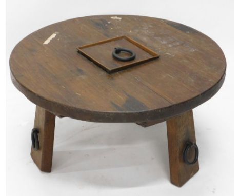 A Continental heavy oak coffee table, the circular top on shaped stiles, with metal ring additions, 42cm high, 77cm diameters