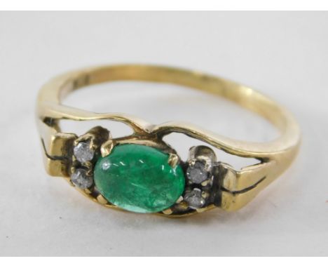 An emerald and diamond dress ring, the oval emerald (flawed) flanked by two tiny diamonds, with raised and mounted shoulders,