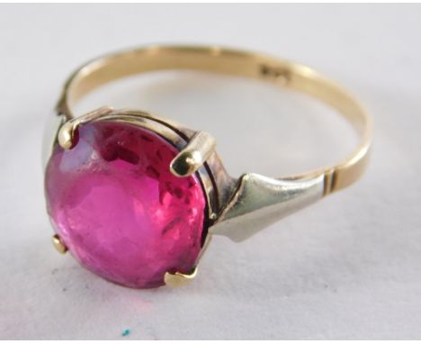 A dress ring set with pink paste stone, in raised basket four claw setting, on a yellow metal band stamped 9ct, ring size L½,