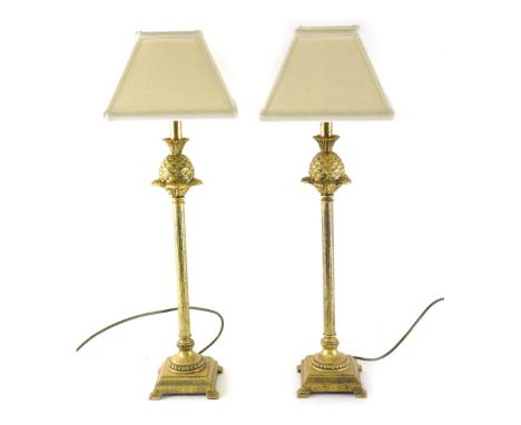 A pair of gilt metal table lamps, with pineapple and fluted stems terminating in step bracket feet with modern shades 71cm hi