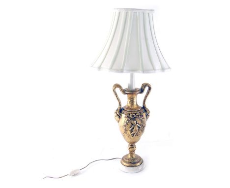 A classical design urn table lamp, with double strap work handles, with a mask head and raised cherub decoration on circular 