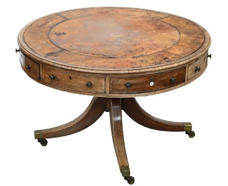 A George IV mahogany library table or 'rent table', the tooled leather inset rotating top with four drawers, each with ivory 