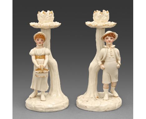 A pair of Royal Worcester figural candlesticks, c1882, designed by James Hadley in the manner of Kate Greenaway,&nbsp;decorat