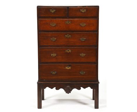 A George III 'caddy-moulded' oak chest of drawers, the apron applied with carved shell, mahogany-stained, 135cm h; 40 x 78cm 