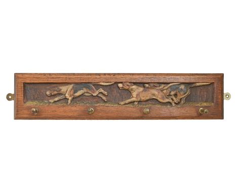 Hunting interest. A carved polychrome oak cap rack,&nbsp;Swaine &amp; Adeney Ltd, London, early 20th c, with four brass pegs,