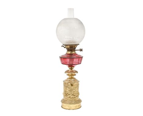 A French cranberry glass oil lamp, c1880, the brass base decorated in relief with a farmyard scene, the globular shade etched