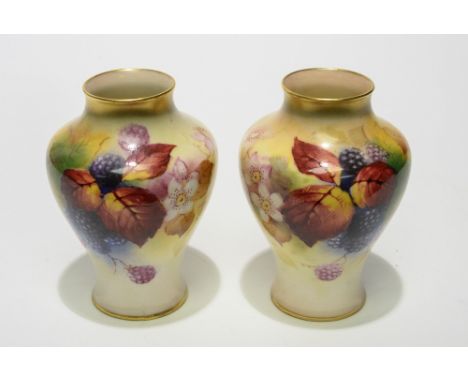 A pair of Royal Worcester vases, circa 1938, painted by Kitty Blake with black berries and foliage, of baluster form, puce ma