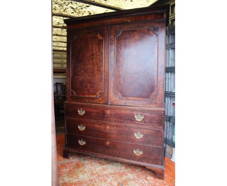 A George III mahogany linen press, the upper section with two doors opening to reveal internal shelves, the base with a long 